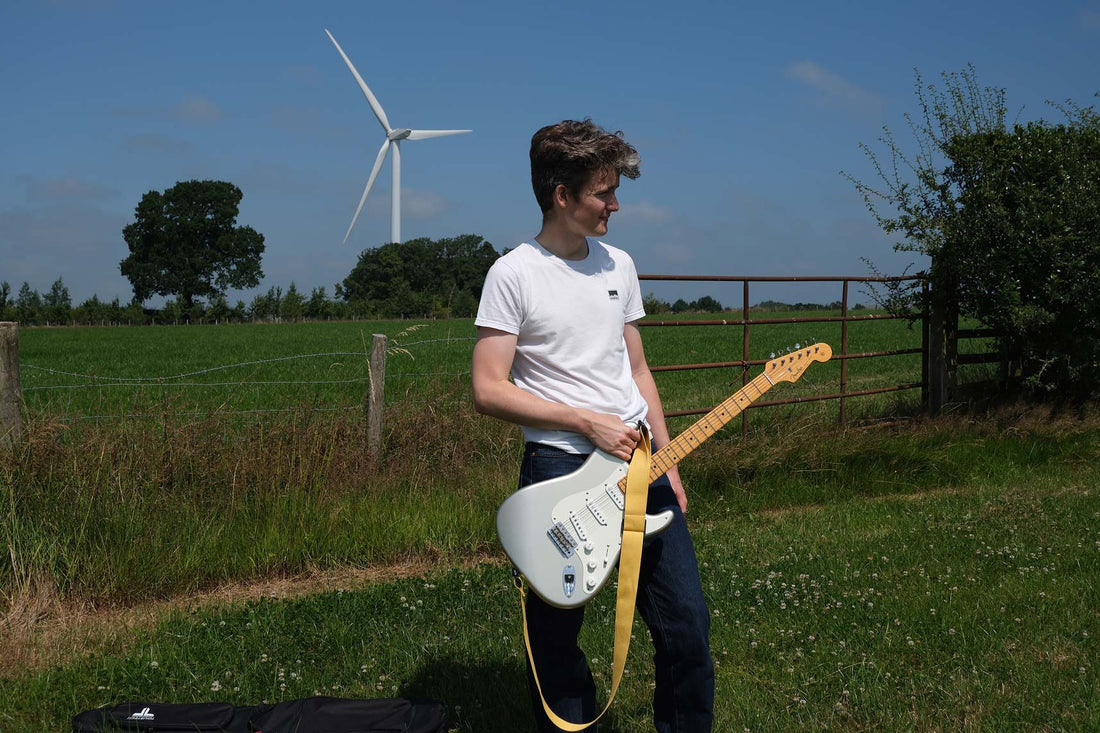 A man holding a Fender Stratocaster fitted with a Reva R1 Locking Guitar Strap.
